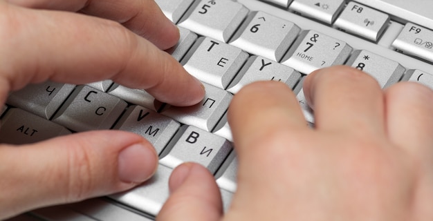 Foto trabajando con los dedos de la computadora portátil en el teclado