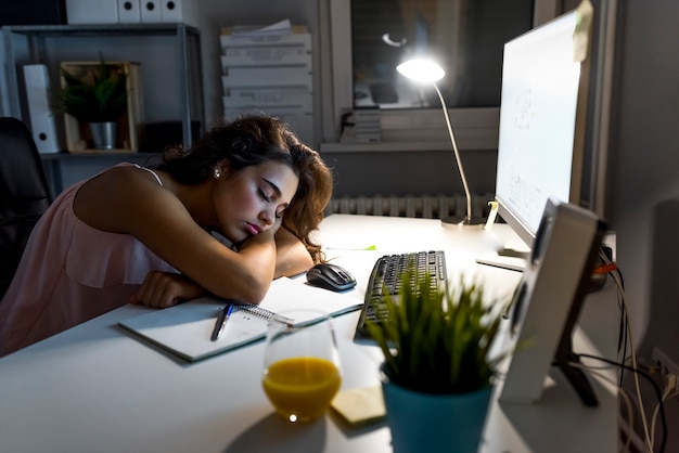 Trabajando duro las mujeres se duermen en la oficina por la noche