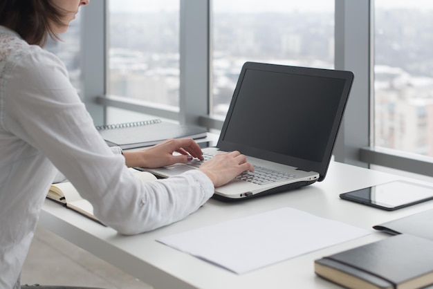 Trabajando con una mujer portátil escribiendo un blog Manos femeninas en el teclado