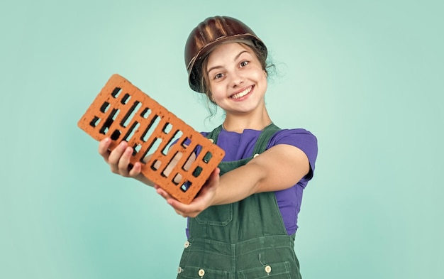 Trabajando en el taller de reparación futuro ingeniero niño feliz usar ladrillo para la renovación reparación del sitio de construcción niño arquitecto trabajador día del trabajo desarrollo infantil adolescente niña asistente