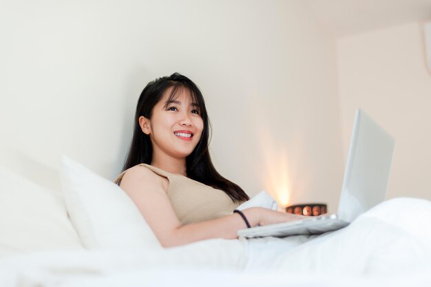 Trabajar en la cama por la mañana con una computadora portátil enviar trabajo en línea hablar en línea comunicarse en línea