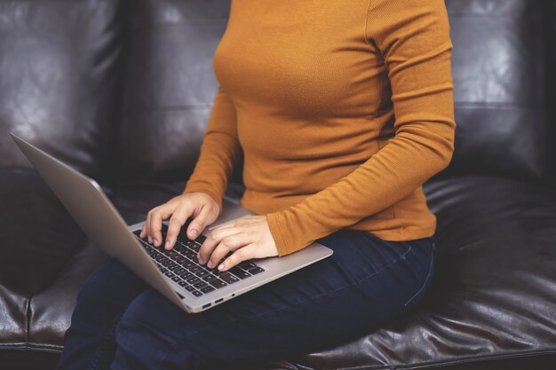 Trabajar desde casa, una mujer que usa un cuaderno Comprar en línea desde casa