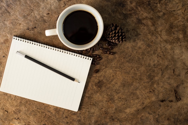 Trabajar con cuadernos y tazas de café en pisos de madera.