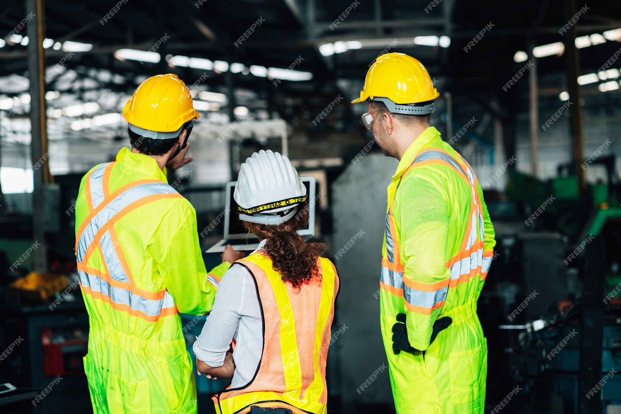 Trabajar en el hombre de los trabajadores y el equipo de la mujer del ingeniero que trabajan juntos en ropa de trabajo de con un casco blanco amarillo usando