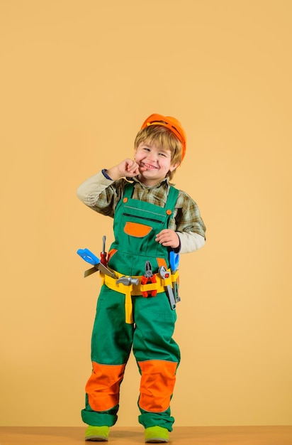 Trabajar con herramientas niño feliz con herramientas para construir juegos infantiles reparación niño en uniforme de constructor