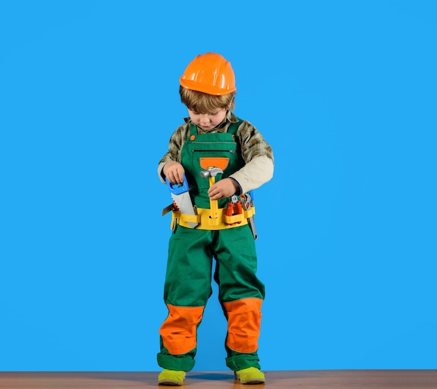 Trabajar con herramientas niño en uniforme de constructores con herramientas de reparación reparar niño como constructor o reparador
