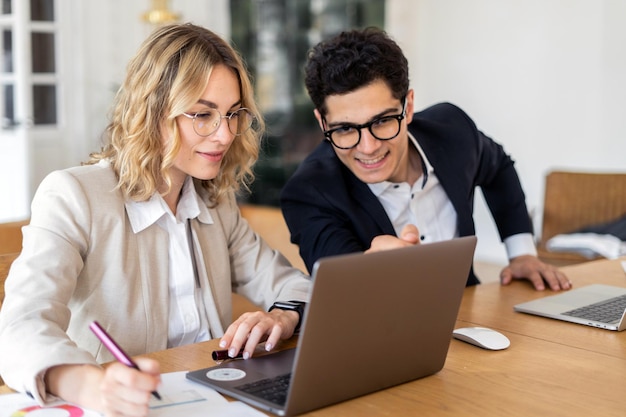 Trabajar en línea, usar computadoras portátiles, empleados, economistas, trabajar en una empresa financiera en la oficina.