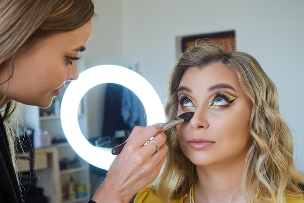 Trabajo entre bastidores de un maquillador profesional en un salón de belleza