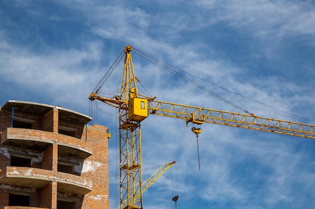 Trabajo en curso en un nuevo bloque de apartamentos Edificio alto en construcción con grúas Sitio de construcción de un nuevo edificio