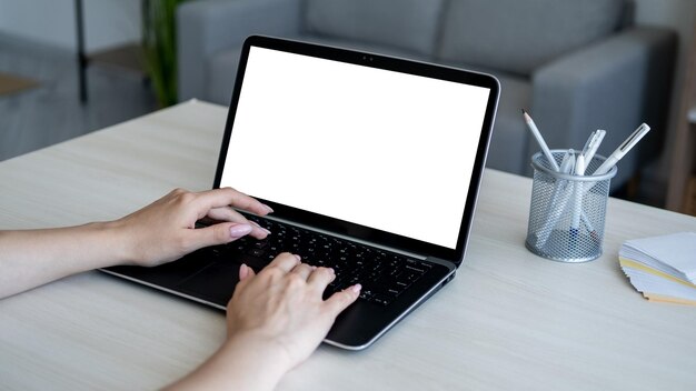 Trabajo a distancia maqueta de computadora vida digital manos femeninas escribiendo portátil pantalla en blanco blanco sentado