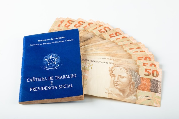 Trabajo de documentos brasileños y seguridad social Carteira de Trabalho e Previdencia Social con billetes de dinero brasileño