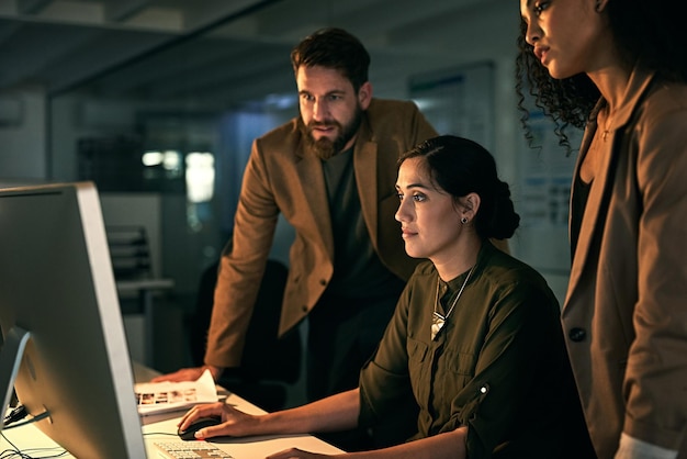 Trabajo en equipo computadora y gente de negocios por la noche para planificar redes en línea y discusión Oficina de creación de startups y hombres y mujeres en la pantalla del ordenador para el sitio web de investigación y la reunión en el escritorio