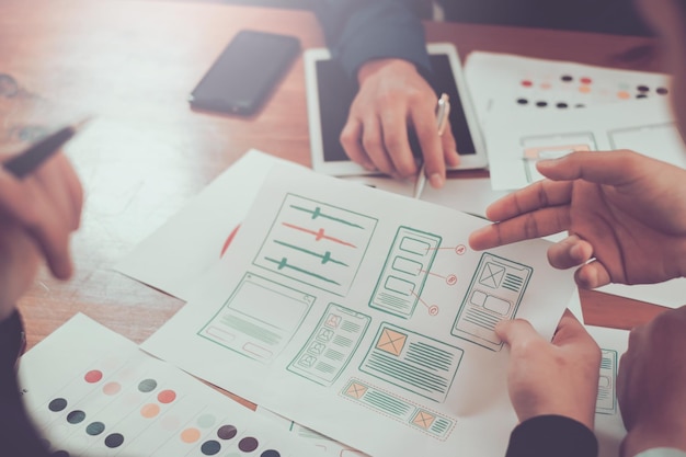Trabajo en equipo diseñadores gráficos desarrollo de aplicaciones de sitios web de dibujo creativo y aplicaciones para teléfonos móviles en la oficina