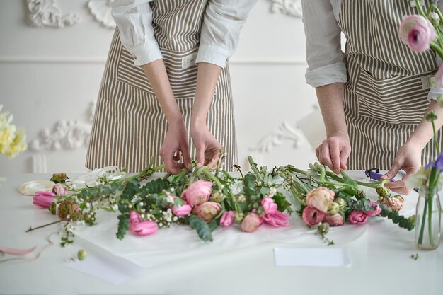 Trabajo en equipo Dos floristas hermosos jovenes crean un ramo