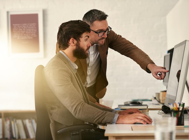 Trabajo en equipo de empresario creativo y pasante de entrenamiento en computadora en diseño web UX o UI en la oficina Personal de capacitación de diseñador de hombres o estudiante en PC para ayuda de apoyo de equipo o puesta en marcha en el lugar de trabajo