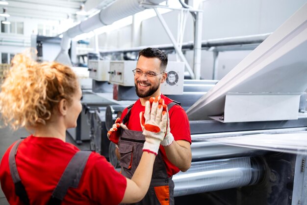 Trabajo en equipo en la fábrica Empleados celebrando el éxito de la producción