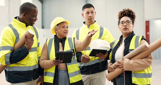 Trabajo en equipo de ingeniería y planificación de personas en la construcción de inspección de almacén o diseño de edificios Gerente de la industria en tableta digital para el plano o el plano de piso con renovación de arquitectura