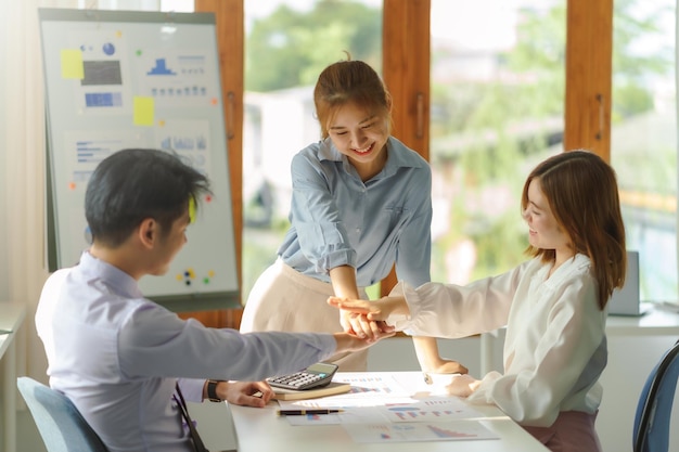 Trabajo en equipo Jóvenes empresarios asiáticos se reúnen y trabajan juntos en un nuevo proyecto de inicio Unidad y concepto de trabajo en equipo