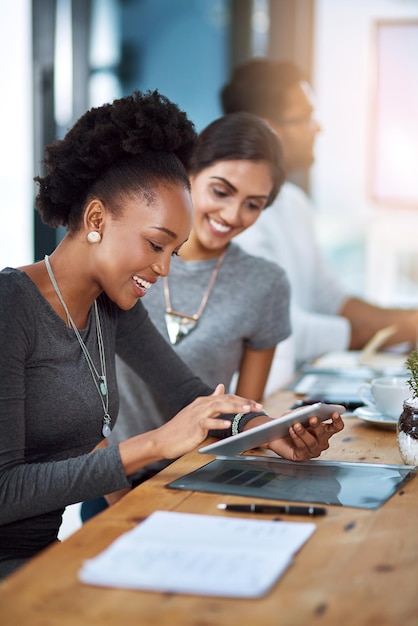 El trabajo en equipo y la productividad van de la mano Foto de dos jóvenes colegas usando una tableta digital juntos en el trabajo