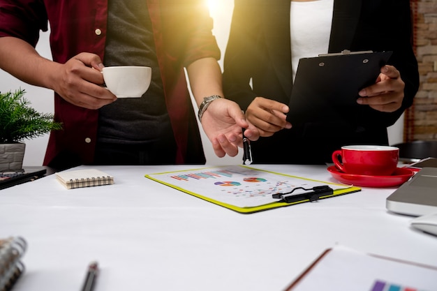 El trabajo en equipo del proyecto empresarial planifica un nuevo proyecto de puesta en marcha, reunión de gerentes de finanzas, teléfono inteligente con diseño de computadora con pantalla de acoplamiento de tableta digital, a la luz de la mañana.