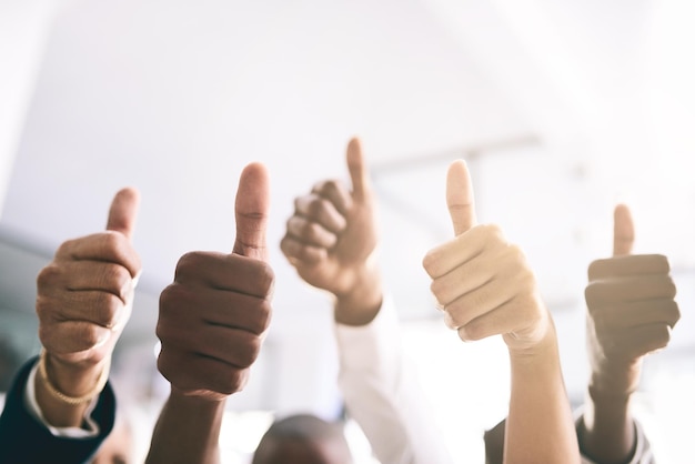 Trabajo en equipo pulgares hacia arriba y personas de negocios de cerca para apoyar el éxito o la celebración de la meta en la oficina Grupo manos juntas y como gesto para la retroalimentación excelencia y gracias por la cooperación