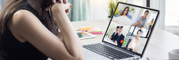 Foto trabajo en el hogar y concepto de distanciamiento social, mujer hablando con sus colegas sobre el plan en una video conferencia en casa, reuniéndose y planificando en línea como covid 19 o enfermedad del virus corona