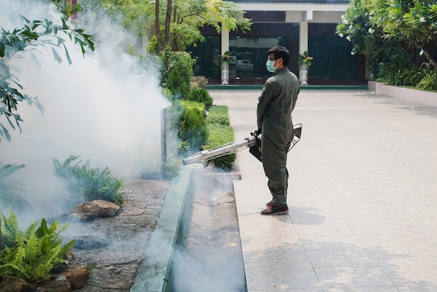 El trabajo del hombre se empaña para eliminar el mosquito y prevenir la propagación de la fiebre del dengue y el virus zika