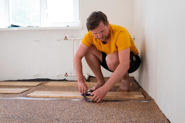 Trabajo de pavimentación. Instalación de capa base en preparación para suelo de parquet de madera