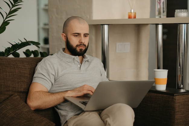 Trabajo remoto. Un hombre que trabaja remotamente en su computadora portátil.