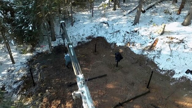 Trabajo en un sitio de construcción durante el invierno clip fondo industrial al aire libre en el bosque de invierno