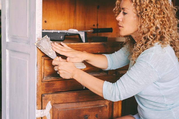 Trabajo de sostenibilidad y reciclaje en casa Mujer joven adulta que trabaja en muebles viejos para crear una nueva decoración elegante y destartalada Reubicación y renovación Actividad de ocio interior manitas trabajo dama