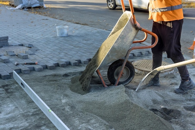 Trabajos de construcción de carreteras con preparación de la superficie para colocar ladrillos de acera de arena arenosa