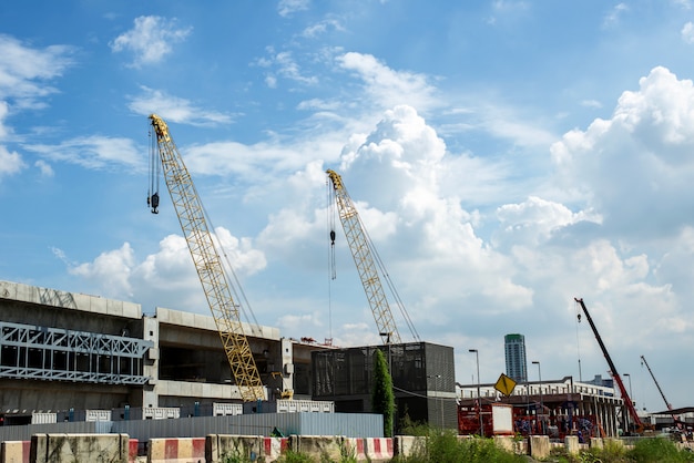 Foto trabajos de construcción de grúas y edificios y cielo azul.