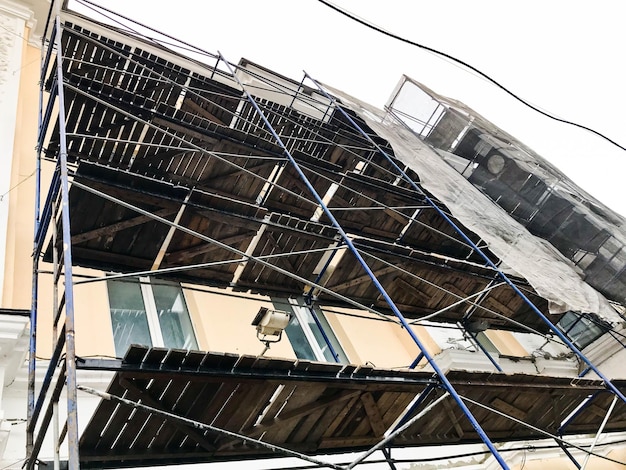 Trabajos de reparación en la fachada del edificio con la ayuda de la restauración de estructuras de andamios de madera