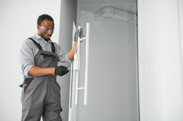 Trabalhador a instalar uma porta de vidro no escritório