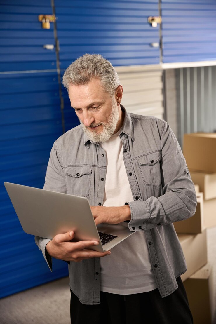 Trabalhador a trabalhar no computador numa unidade de armazenamento