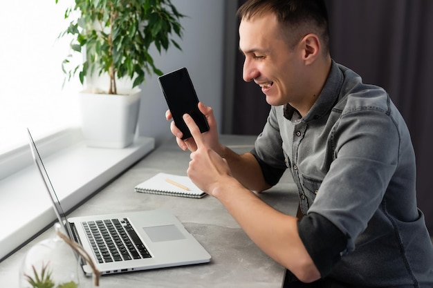 Trabalhador animado sentado na mesa no espaço de coworking usa a mensagem de leitura do computador olhando para a tela do dispositivo recebeu uma grande oportunidade ou recompensa inacreditável. empregado motivado comemorando a promoção de emprego.