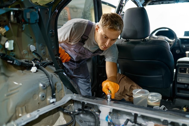 Trabalhador automotivo envolvido no trabalho do corpo do carro