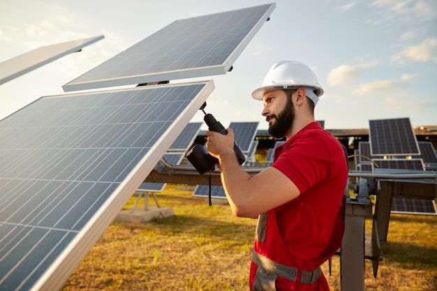 Trabalhador barbudo consertando painel fotovoltaico