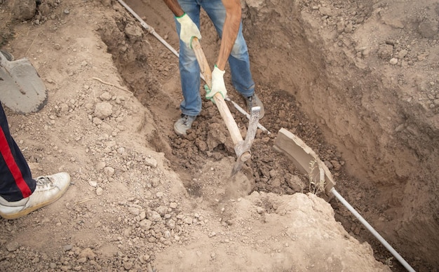 Trabalhador caucasiano cavando um buraco