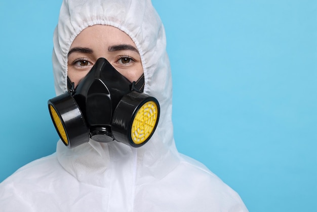 Trabalhador com respirador e fato de proteção em espaço de fundo azul claro para texto