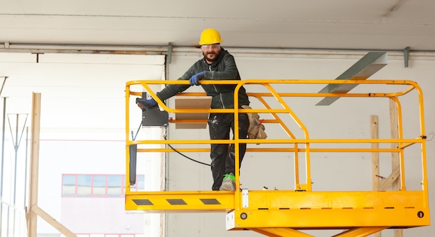 Trabalhador constrói uma parede de gesso cartonado