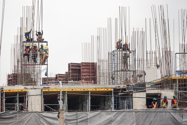 Trabalhador da construção a trabalhar num canteiro de obras contra um céu limpo