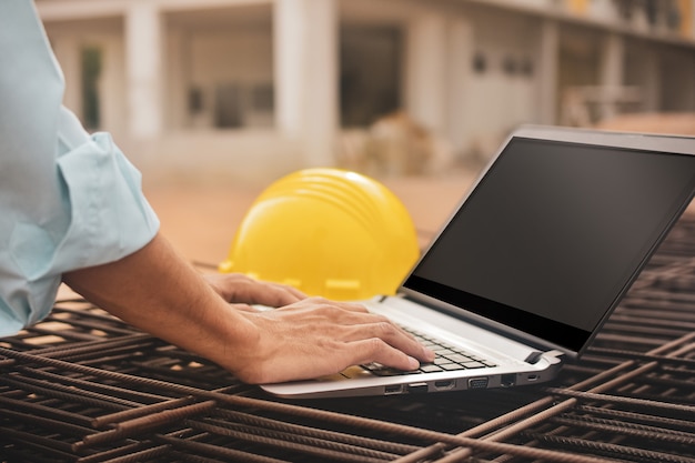 Trabalhador da construção civil close-up usando capacete de computador na construção de site