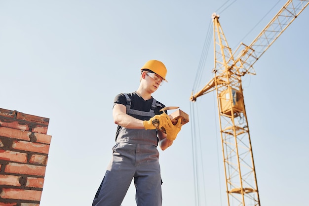 Trabalhador da construção civil em uniforme e equipamento de segurança tem trabalho na construção