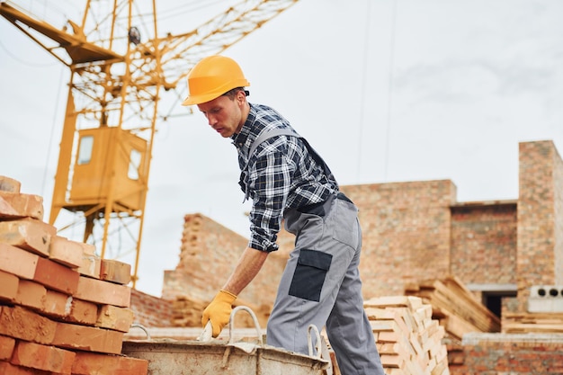 Trabalhador da construção civil em uniforme e equipamento de segurança tem trabalho na construção