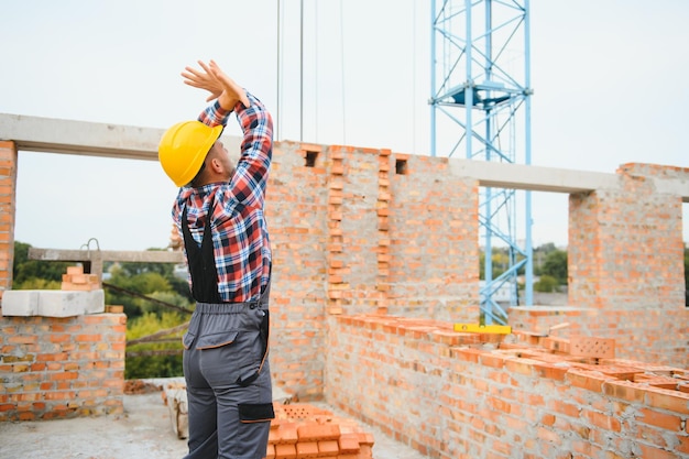 Trabalhador da construção civil em uniforme e equipamento de segurança tem trabalho na construção