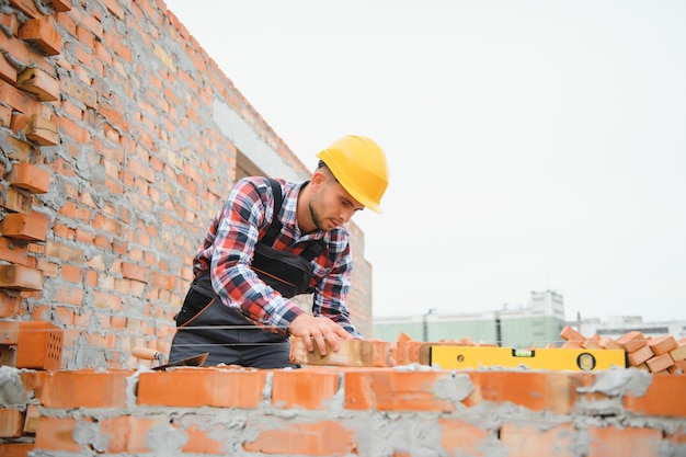 Trabalhador da construção civil em uniforme e equipamento de segurança tem trabalho na construção