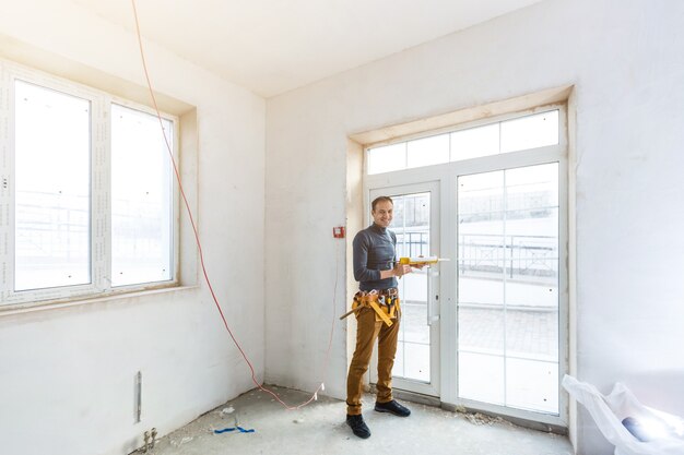 Trabalhador da construção civil instalando janela em casa