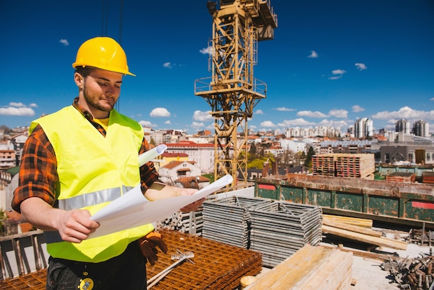 Trabalhador da construção com planos